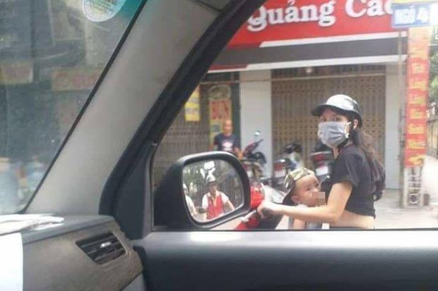 Mẹ trẻ Hà Nội vừa đi xe máy vừa thản nhiên vạch áo cho con bú khiến nhiều người nóng mắt-1