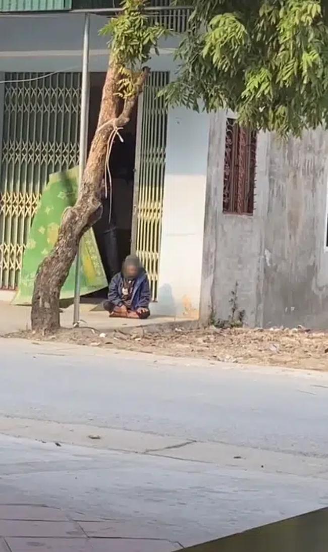 Cụ ông mỏi mệt, ngồi nghỉ chân trước cửa của một nhà dân bên đường